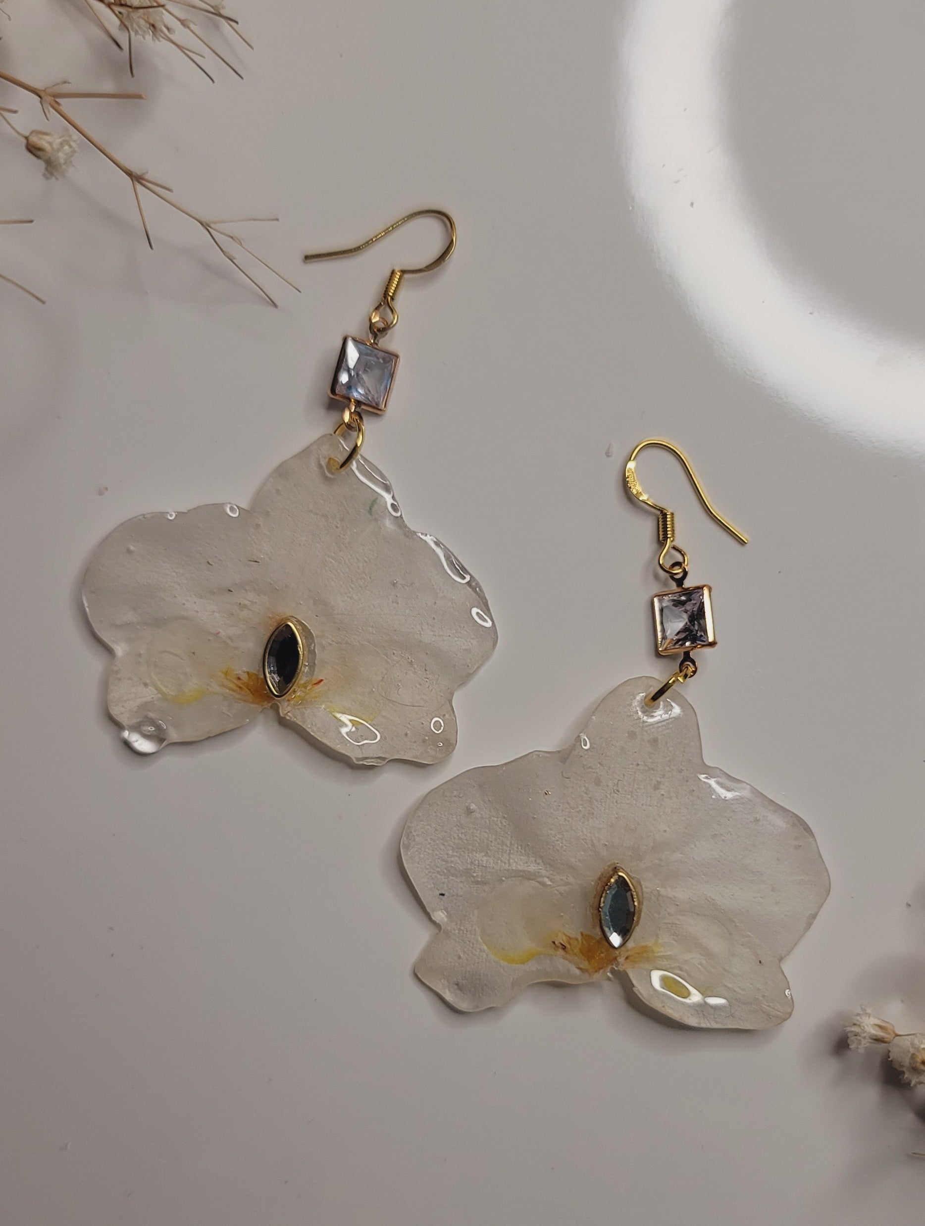 Floral earrings with gold hooks on a light background