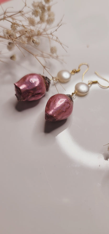Pair of earrings with pink and pearl elements on a light background 